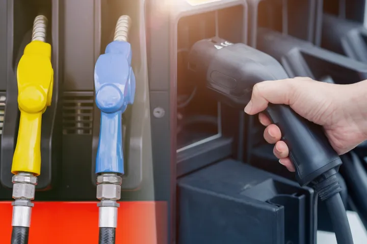 Vue rapprochée de trois pistolets de pompe à essence dans une station-service, avec un pistolet tenu par une main. Les pistolets sont de couleur jaune, bleu et noir, indiquant différents types de carburant.